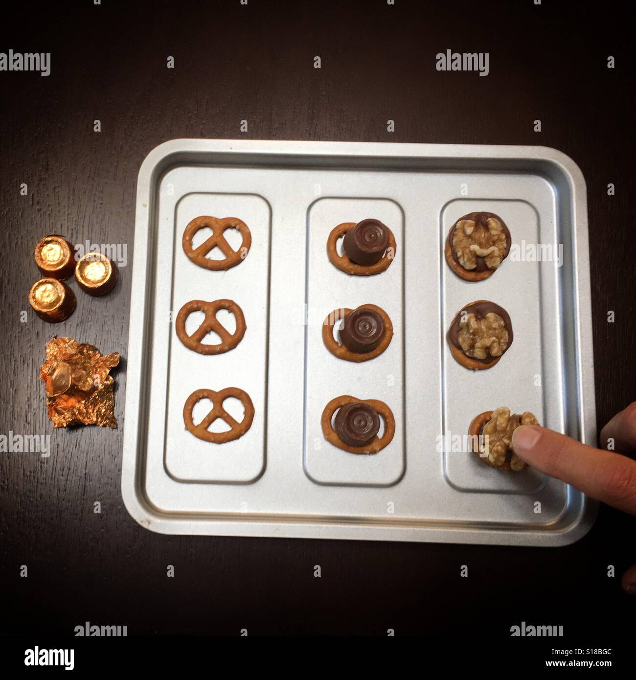 Easy recipe: pretzels, chocolates (Rolos), topped with walnuts - Smartphone Captured Stock Image