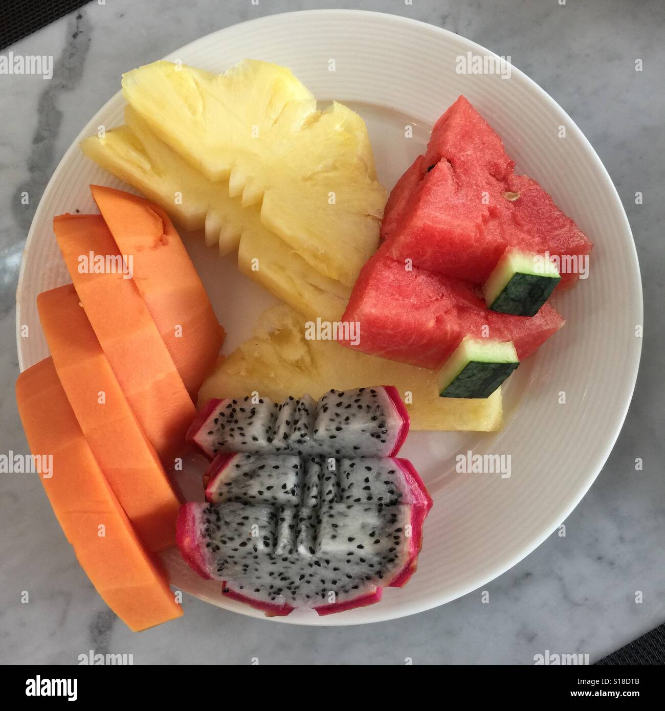 A platter of sliced fruits papaya, pineapple, water melon and
