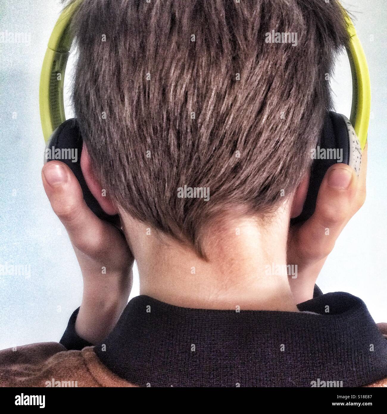 A young boy listening to music on his headphones Stock Photo
