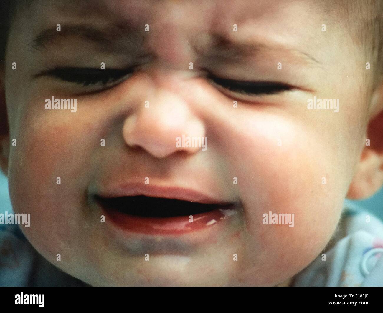 A close up image of a baby who is crying angrily Stock Photo
