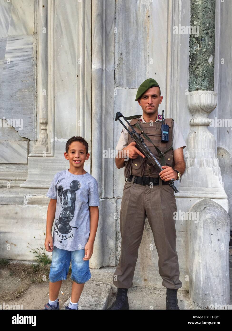 A tourist kid taking picture with Turkish palace Security Guard - Smartphone Captured Stock Image