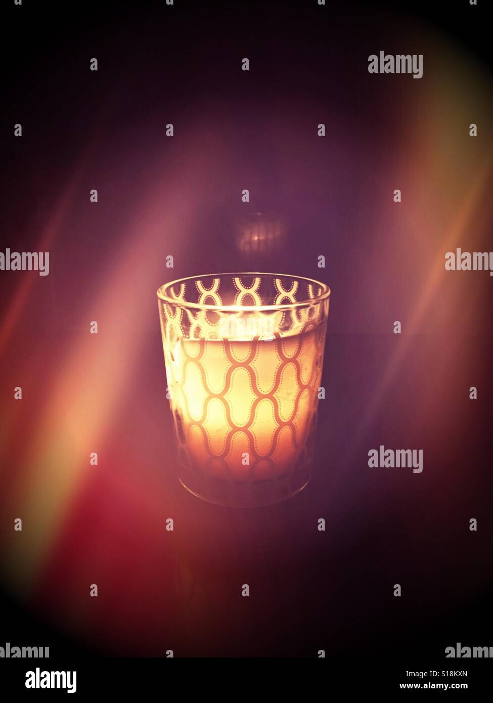 Glowing lit candle giving off soft candlelight Stock Photo Alamy