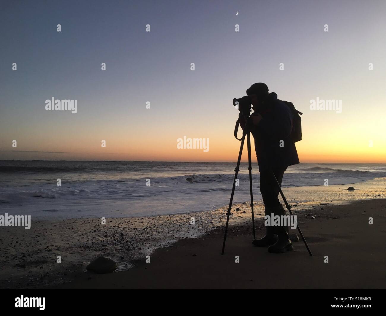 Photographer in silhouette at Spurn Point, Humberside, UK - Smartphone Captured Stock Image