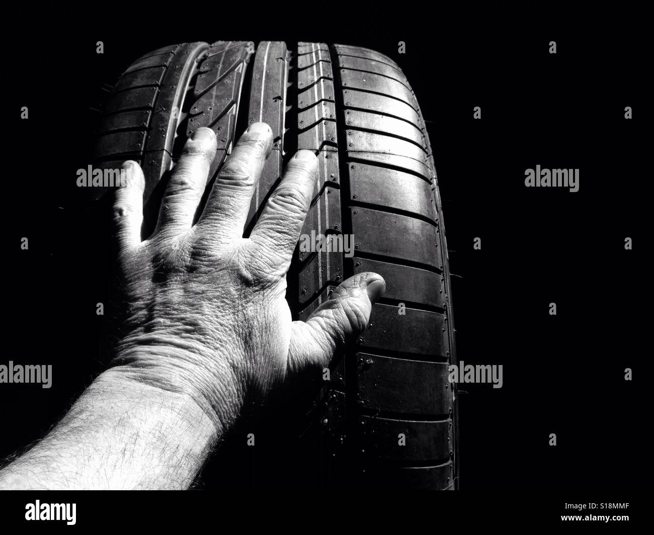 Auto mechanic is holding a Car tire Stock Photo