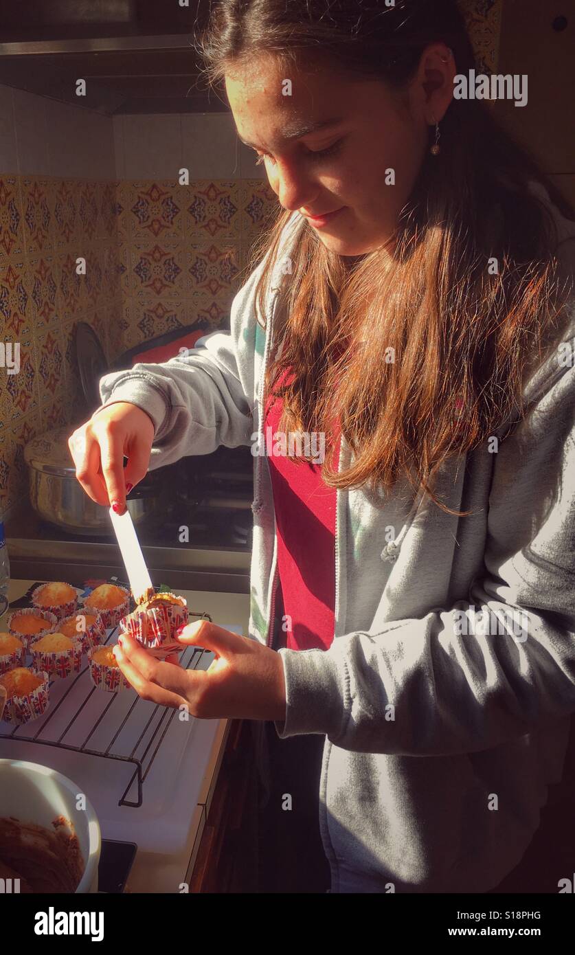Teenager putting icing on to home baked cupcakes - Smartphone Captured Stock Image
