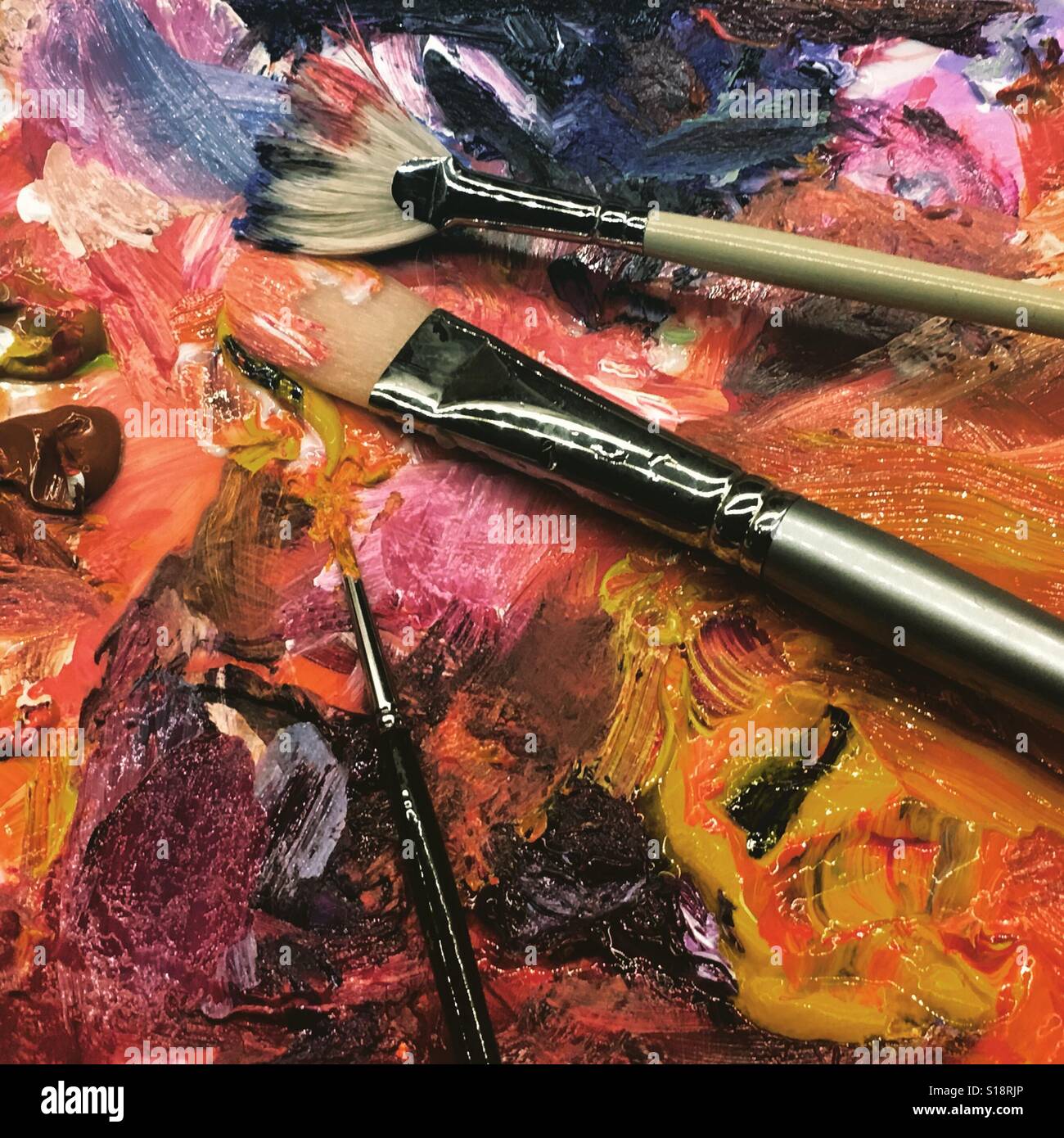 Artists paint palette on a dinner plate with three brushes, close up. Mobile phone photo with mobile device post processing. - Smartphone Captured Stock Image