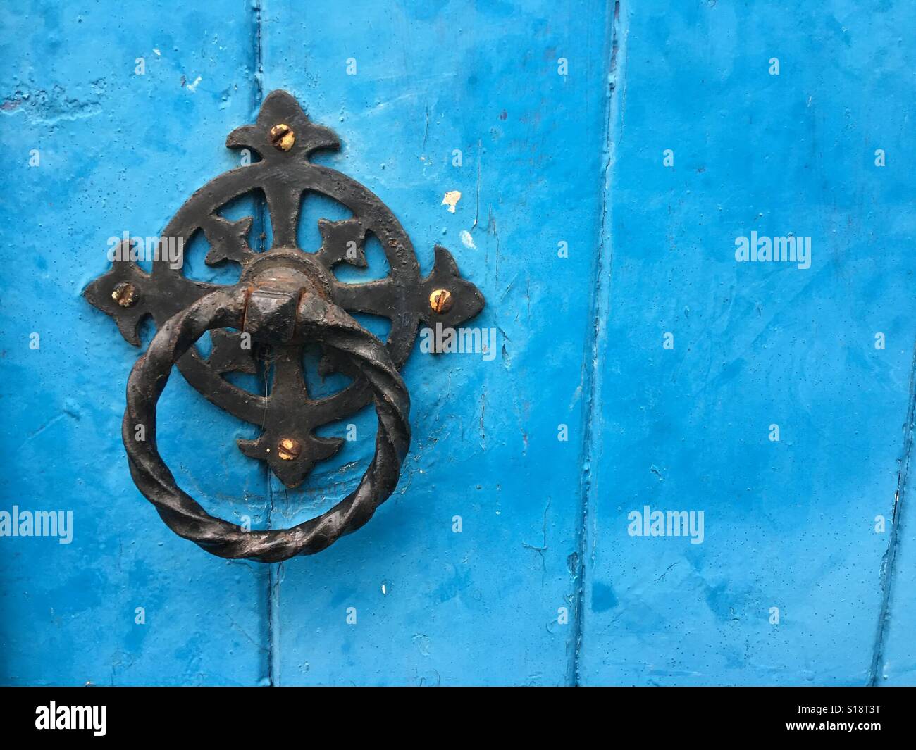 Old style wrought iron door handle on painted blue background - Smartphone Captured Stock Image