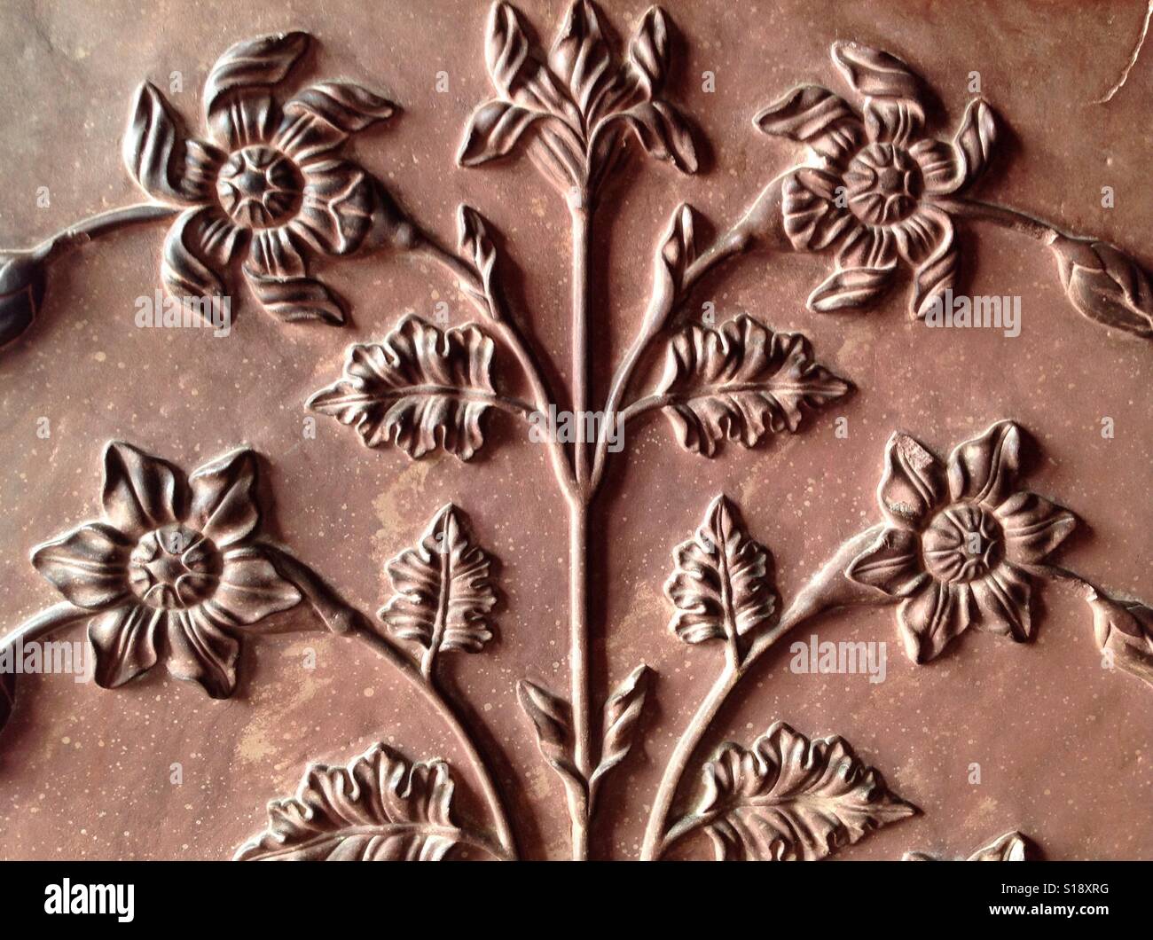 Floral motif in red sandstone at Akbar's Tomb at Sikandra in Agra, India Stock Photo
