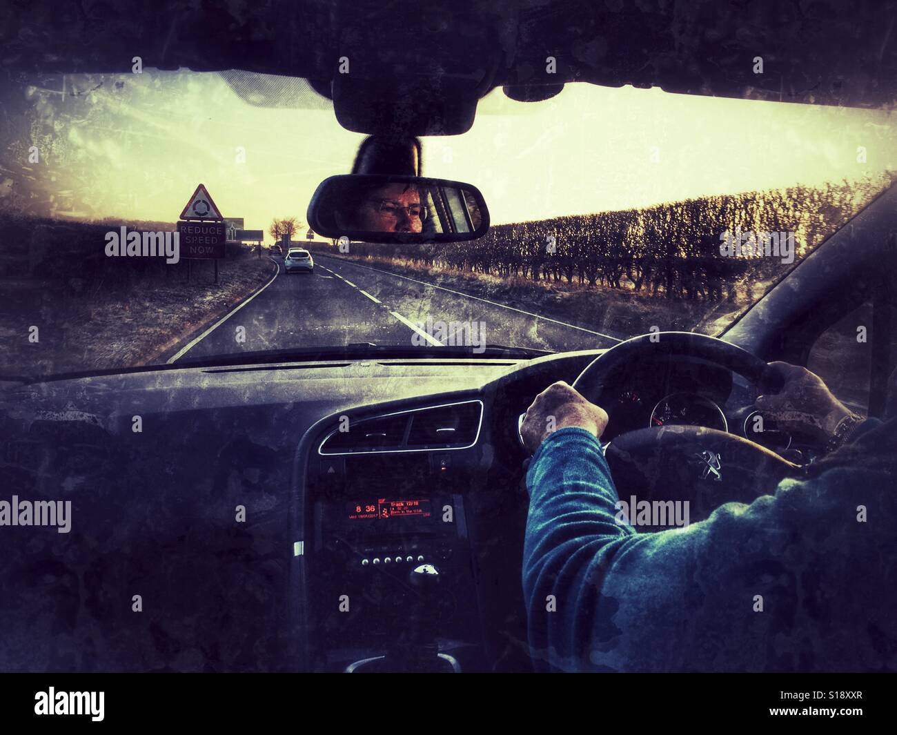 POV driving on the A303 in the early morning. Driver reflected in rear view mirror. - Smartphone Captured Stock Image