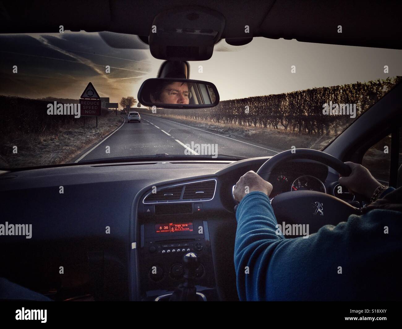 POV Driving on the A303, early morning. Driver reflected in rear view mirror. - Smartphone Captured Stock Image