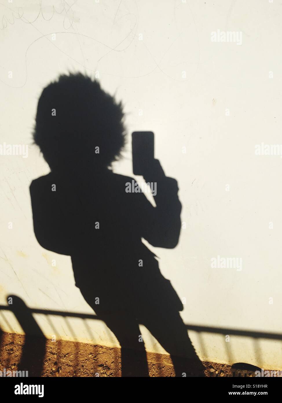 Shadow of a young lady taking a selfie, Stock Photo