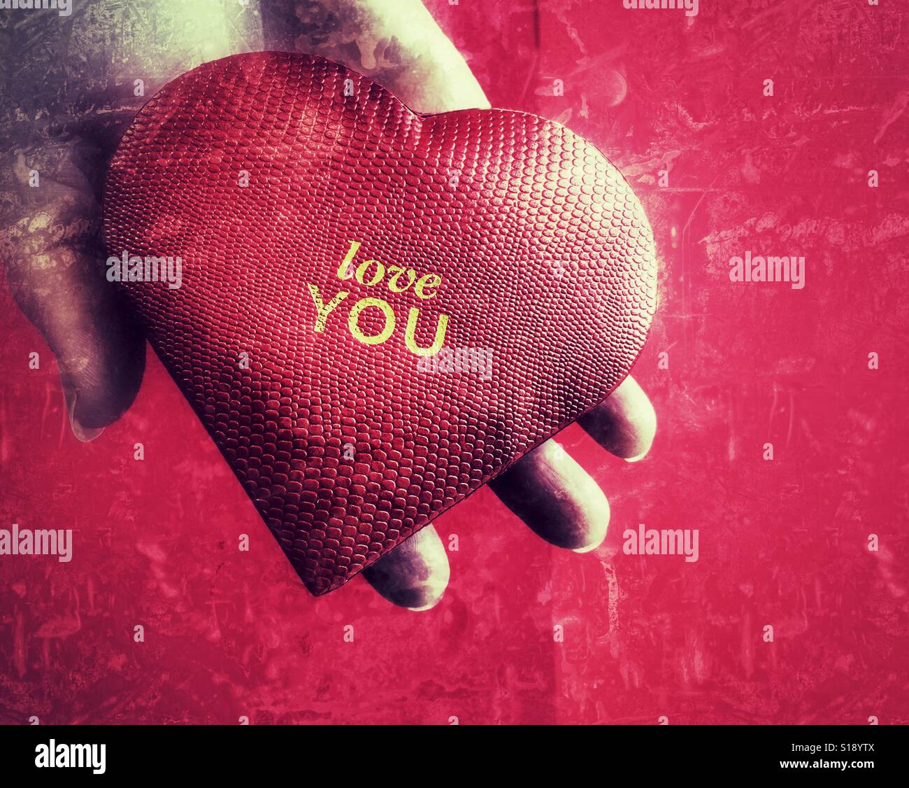 Love you. Red heart shaped box in hand - Smartphone Captured Stock Image