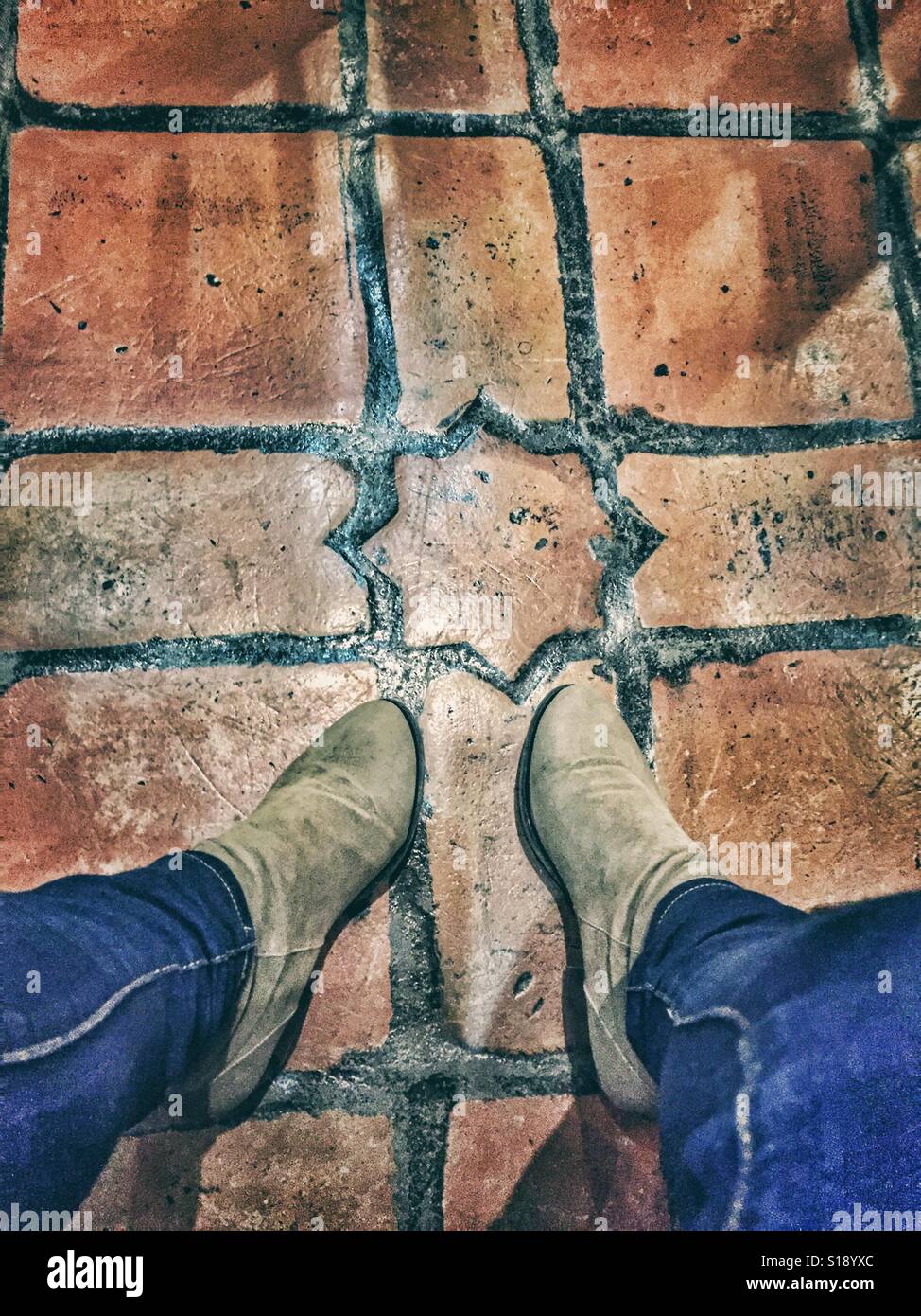 Boots on Spanish Terracotta tiled floor Stock Photo