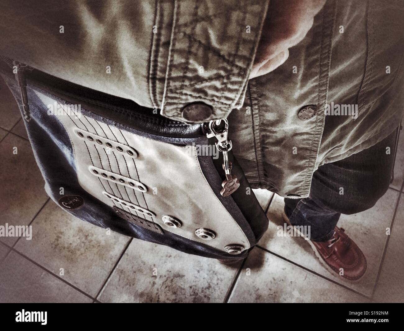 Carrying a guitar shaped shoulder bag. - Smartphone Captured Stock Image