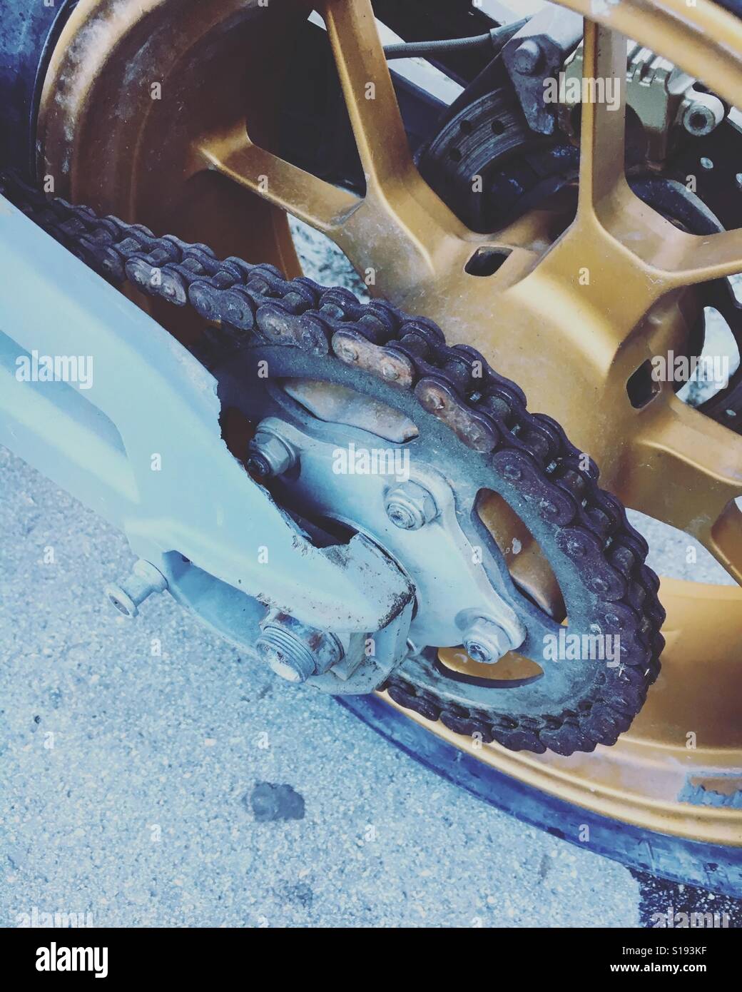 Dirty motorcycle rear wheel and rusty chain Stock Photo Alamy