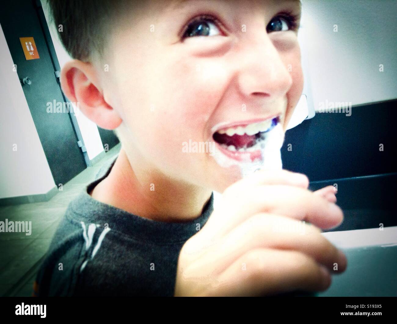 Boy cleaning his teeth, child burnishing his teeth with a toothbrush Stock Photo