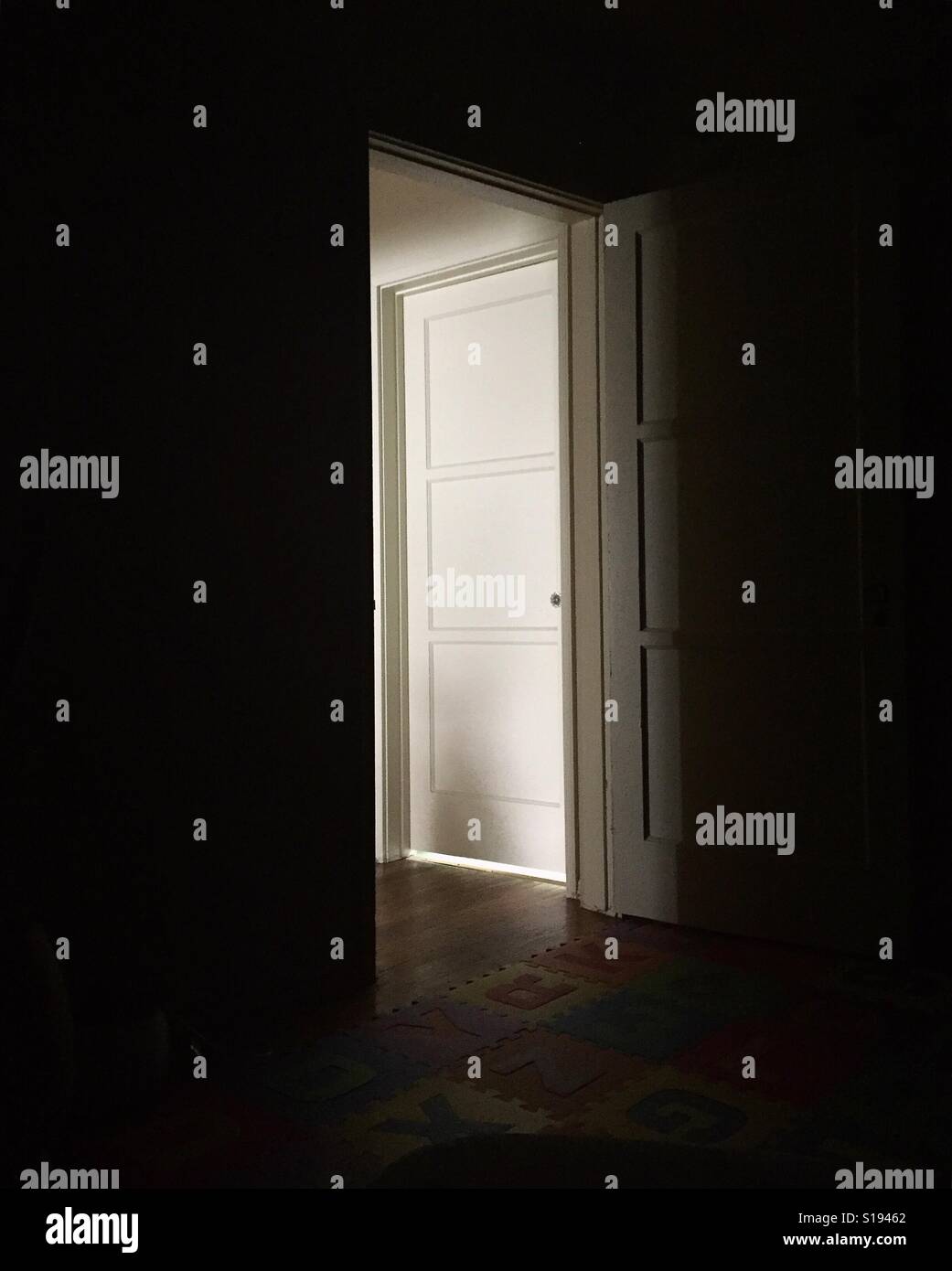 Dark room with white door Stock Photo