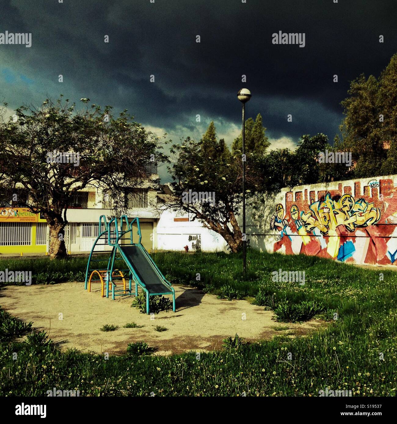 A children's slide is seen at the playground while a usual afternoon storm approaches in Quito, Ecuador, 16 November 2014. Stock Photo