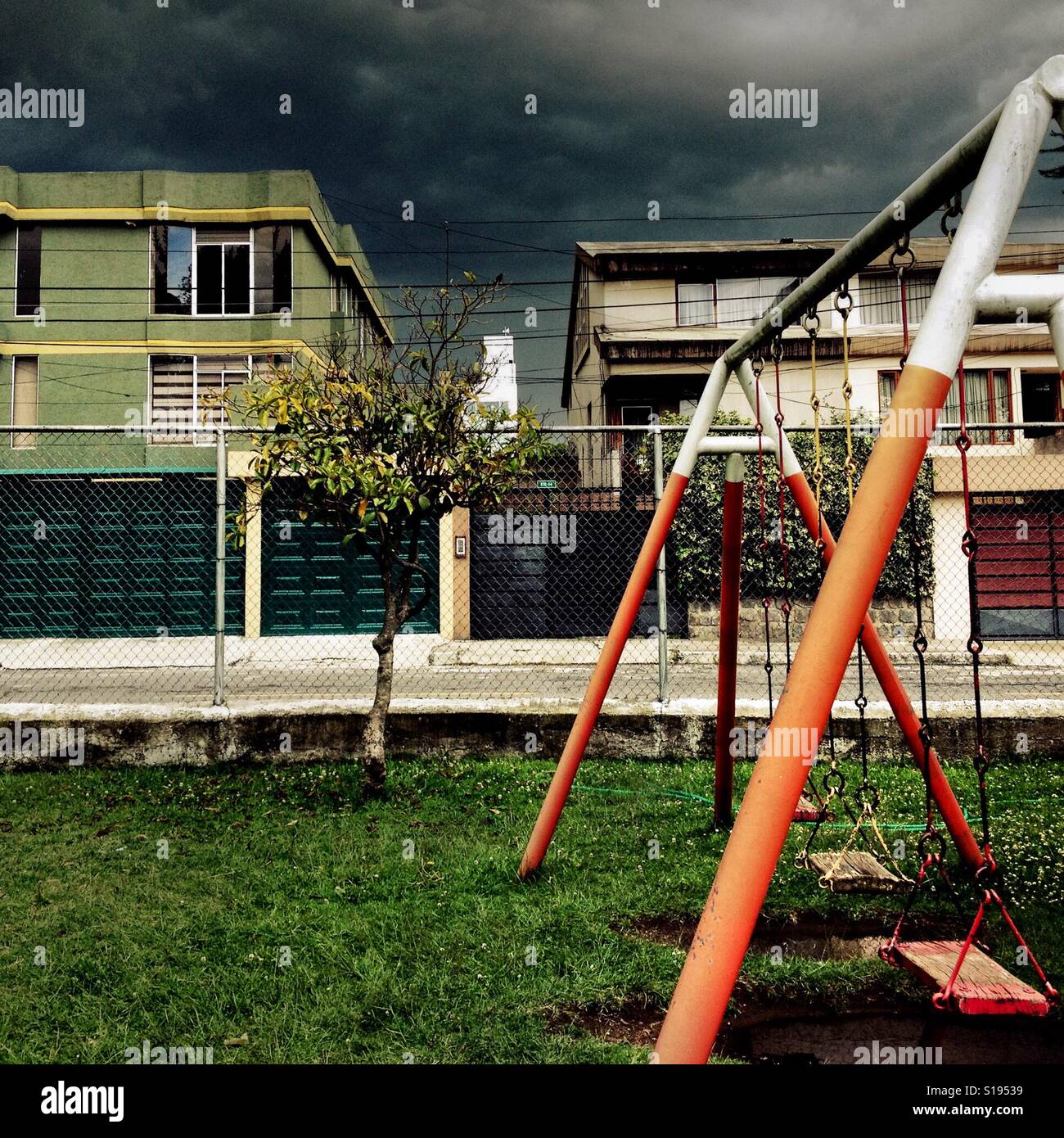 A children's swing is seen at the playground while a usual afternoon storm approaches in Quito, Ecuador, 19 October 2014. Stock Photo