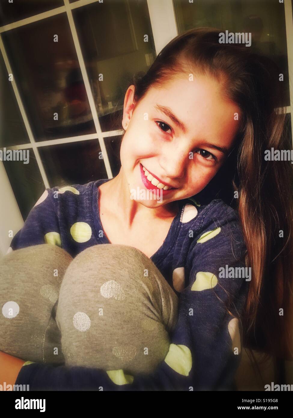 Smiling girl hugging her knees Stock Photo - Alamy