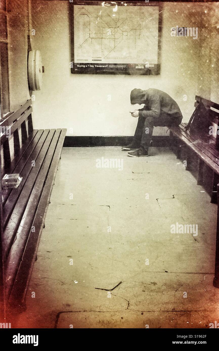 Teenage kid on phone in waiting room - Smartphone Captured Stock Image