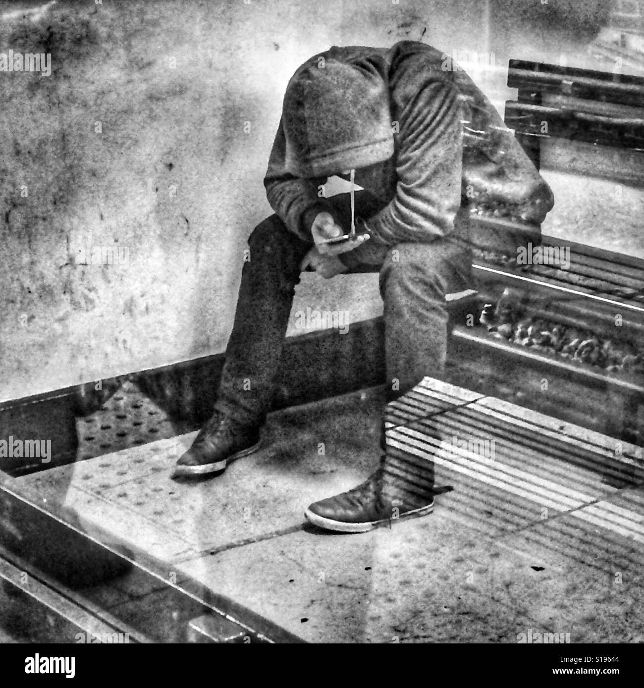 Teenage lad in hooded top on his mobile phone - Smartphone Captured Stock Image