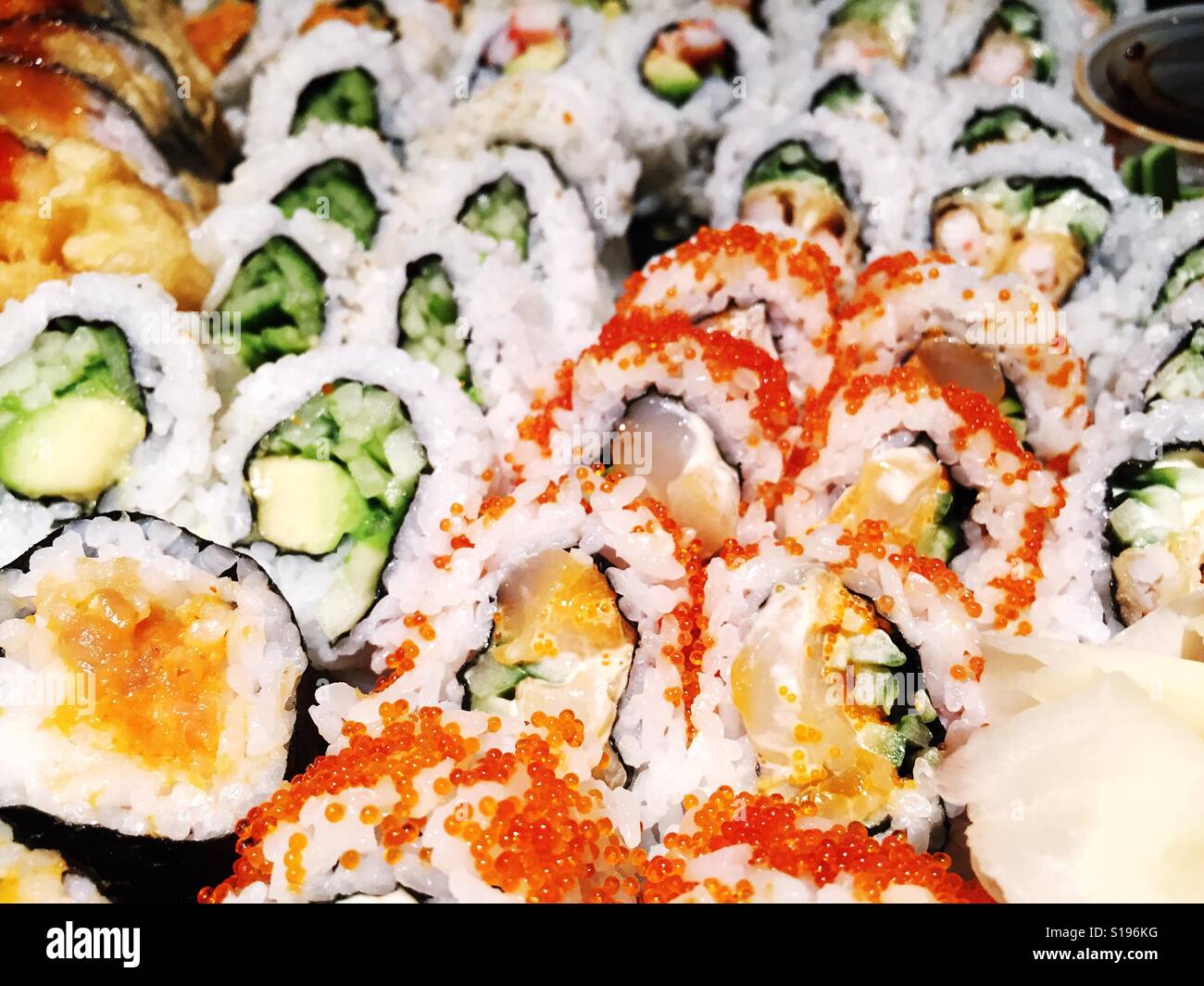 Close up of an assortment of freshly prepared sushi rolls. Bright edit. - Smartphone Captured Stock Image