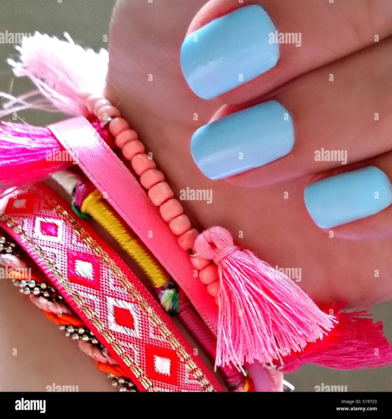 Blue Nail Polish and Colorful Bracelets Stock Photo