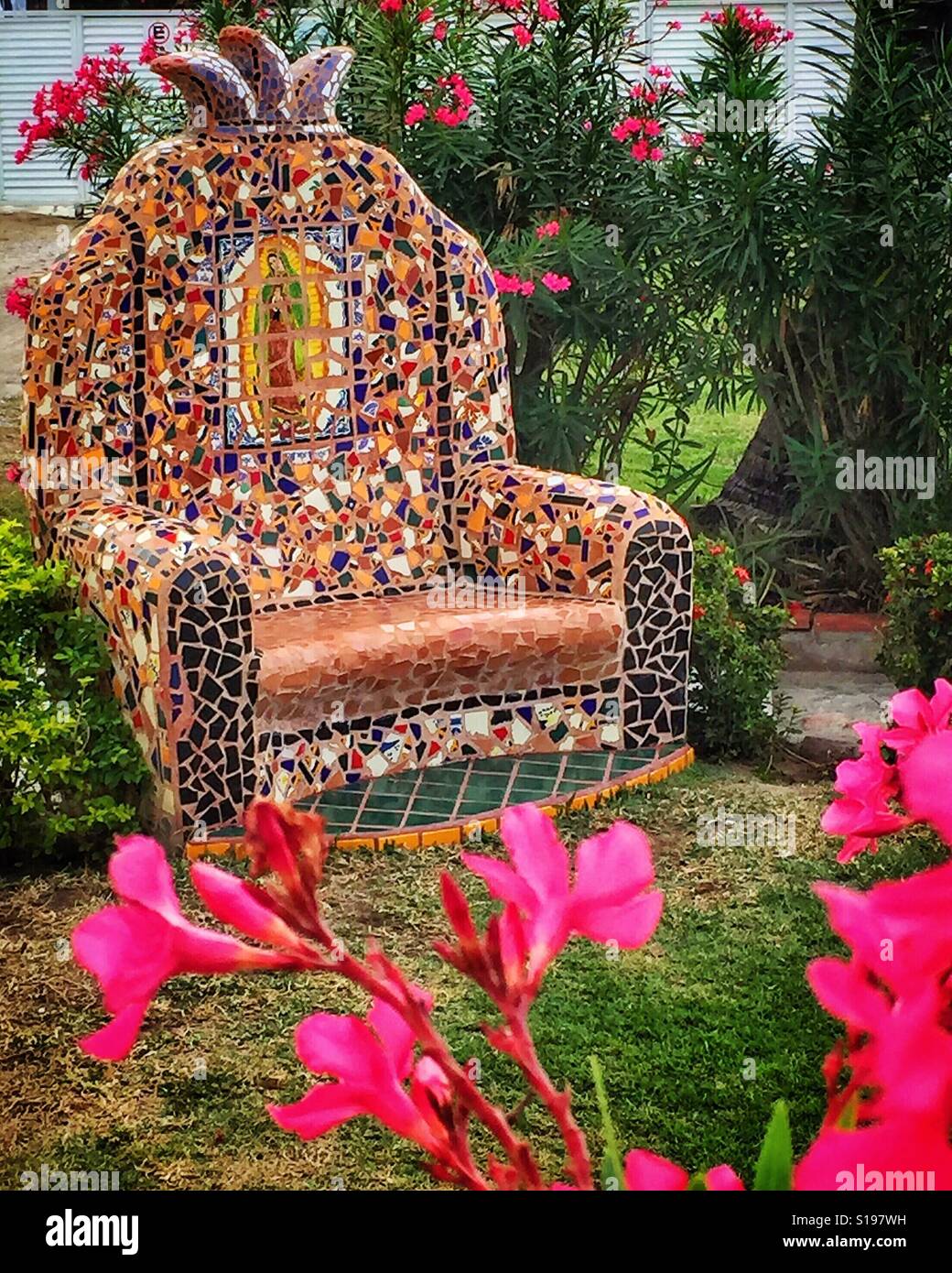 A mosaic tile covered concrete chair adorns a garden in Bucerias, Nayarit. Stock Photo