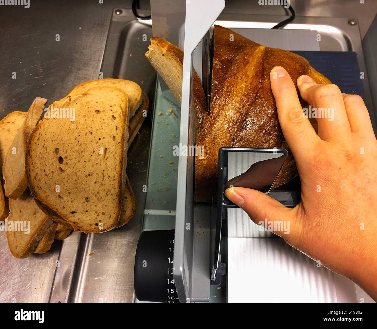 https://c8.alamy.com/comp/S19802/hand-cutting-bread-with-a-bread-slicer-machine-S19802.jpg