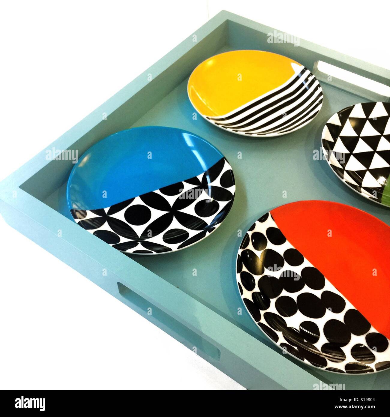 Colorful plates on an Aqua blue tray against a white background - Smartphone Captured Stock Image