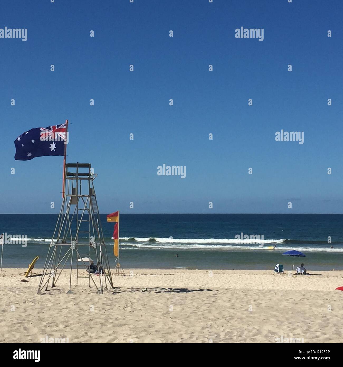 Australian flag and lifesaving flags waving on the beach at Kingscliff, New South Wales. Stock Photo