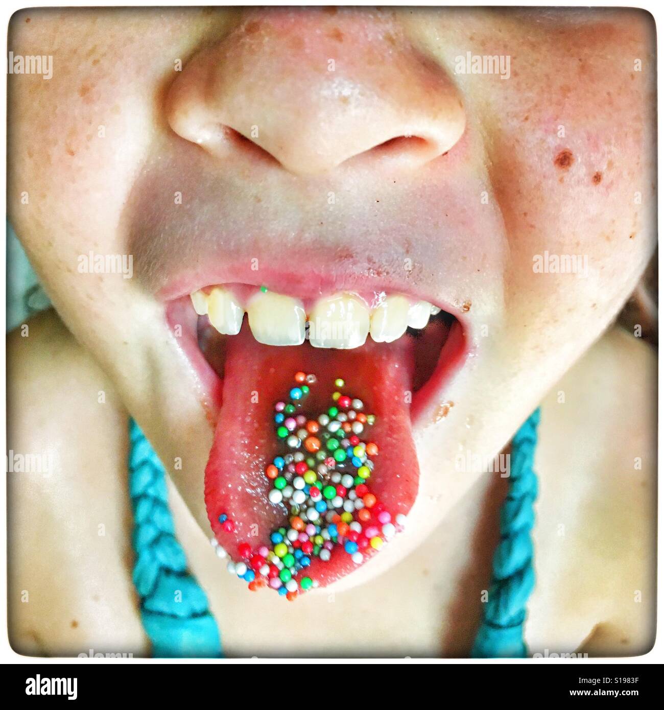 Hundreds and Thousands on a child tongue. - Smartphone Captured Stock Image