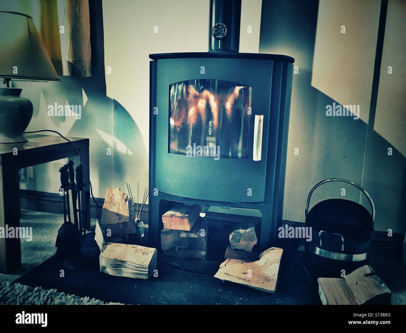 Keeping cosy. Blazing fire in a multi fuel burner - Smartphone Captured Stock Image