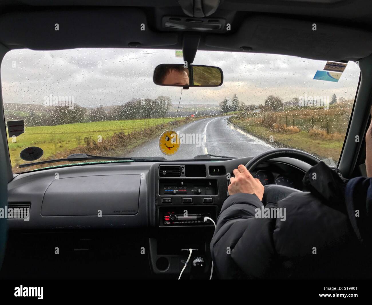 Driving in the rain on the country road, in Northumberland, England Stock Photo