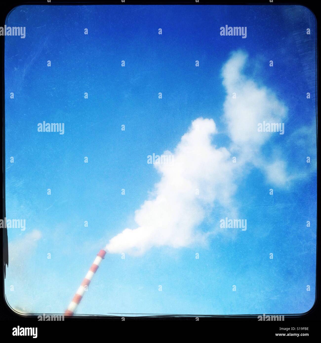 View from window, smoke stack and a blue sky contrast Stock Photo - Alamy