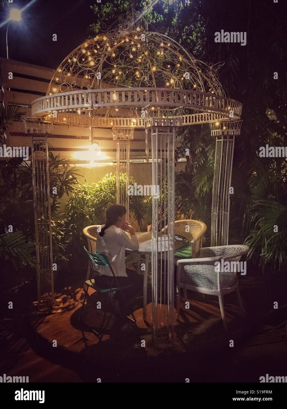 Woman relaxing in the garden at night Stock Photo - Alamy