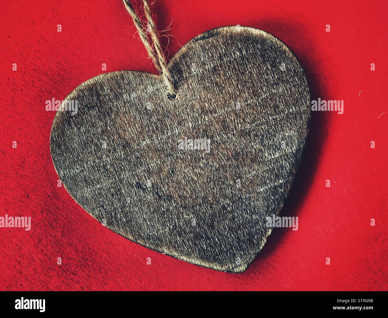 Wood heart shape on red - Smartphone Captured Stock Image