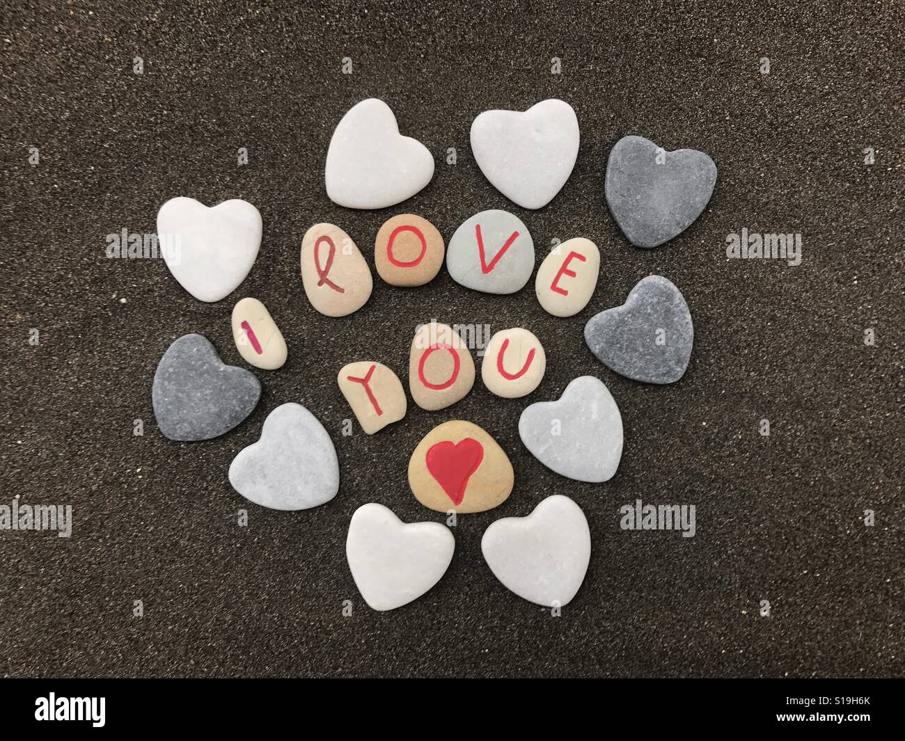 I love you message with stones composition over volcanic black sand Stock Photo
