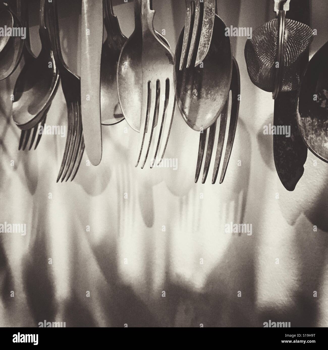 Kitchen utensils hanging on a wall Stock Photo - Alamy