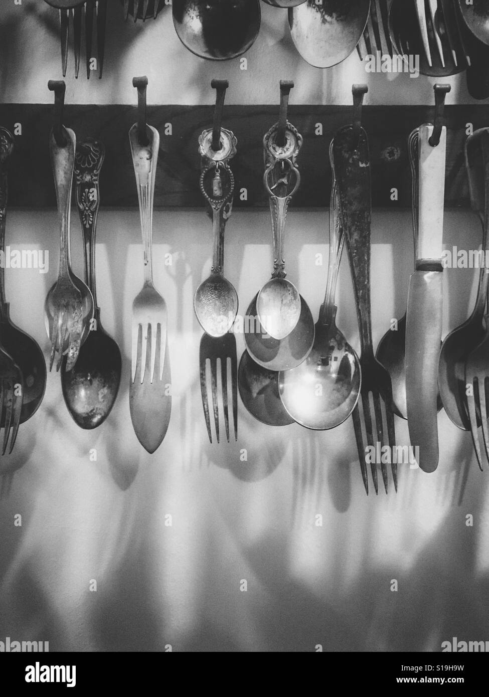 Knives, forks and spoons hanging on a wall Stock Photo Alamy