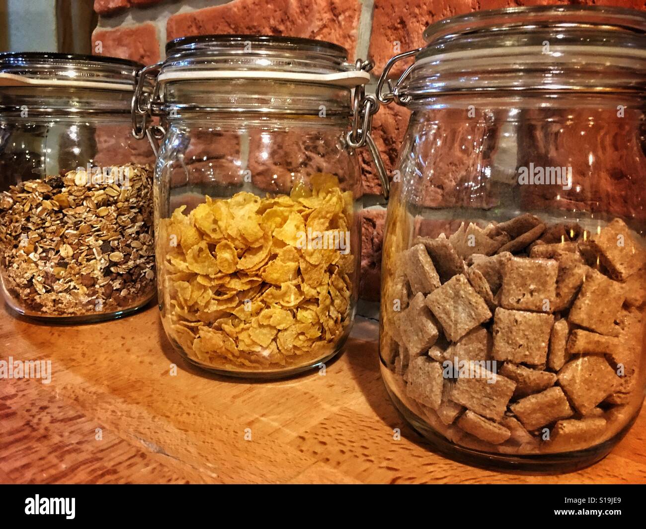 Three jars filled with cornflakes, müsli and other meal for breakfast Stock Photo