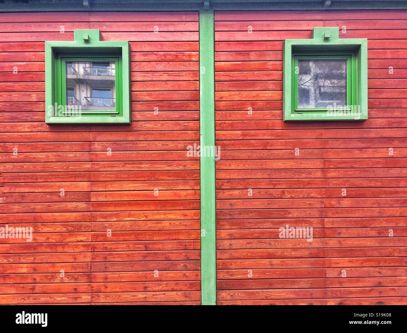 Two green windows on a wooden facade Stock Photo