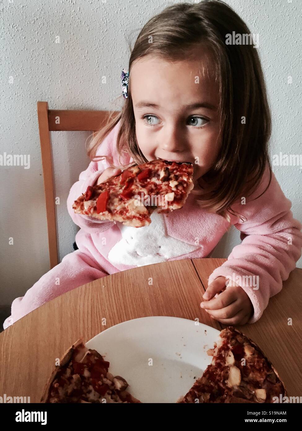 Little girl eating a pizza Stock Photo