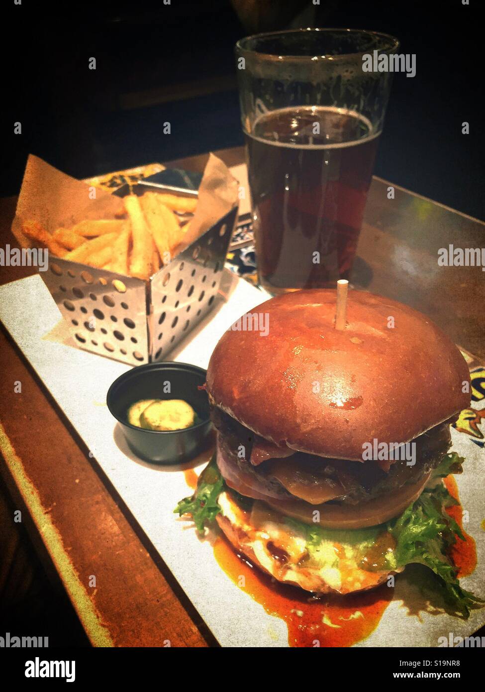 Hamburger, fries and a beer at a restaurant - Smartphone Captured Stock Image