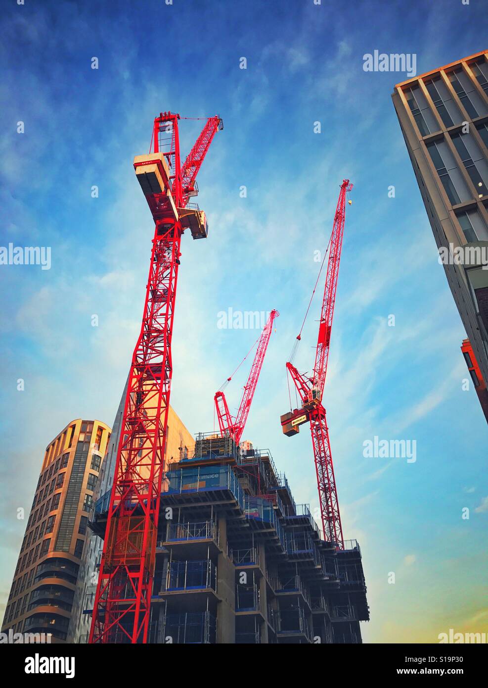 A trio of red cranes on a construction site in central London - Smartphone Captured Stock Image
