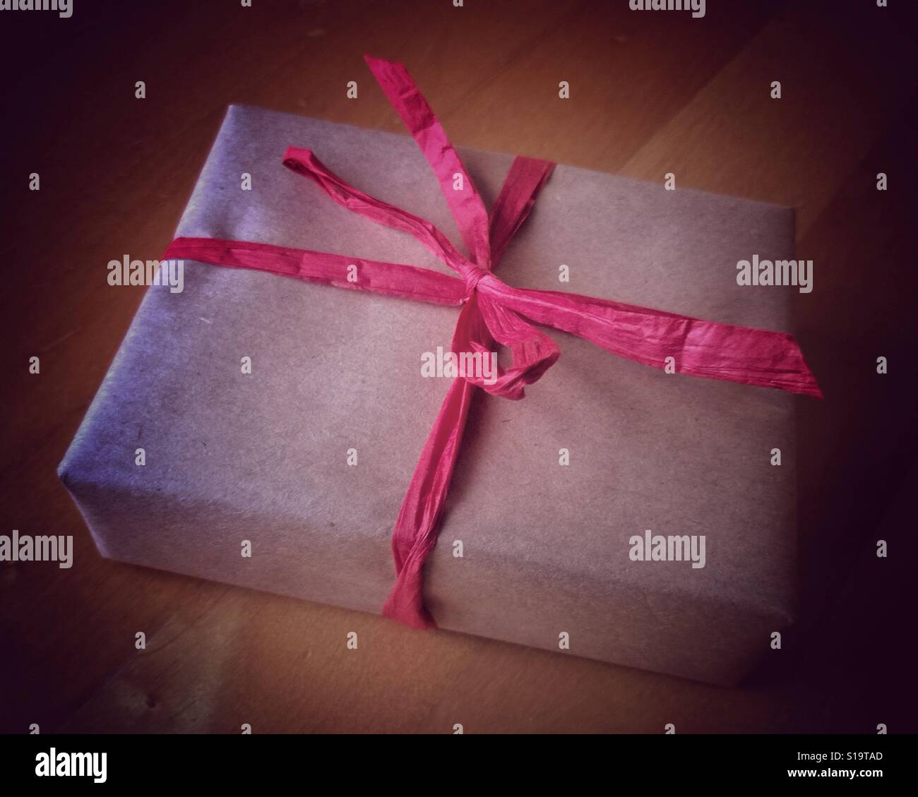 Thriftmas Gift wrapped simply and sustainably with plain brown paper and ribbon. - Smartphone Captured Stock Image