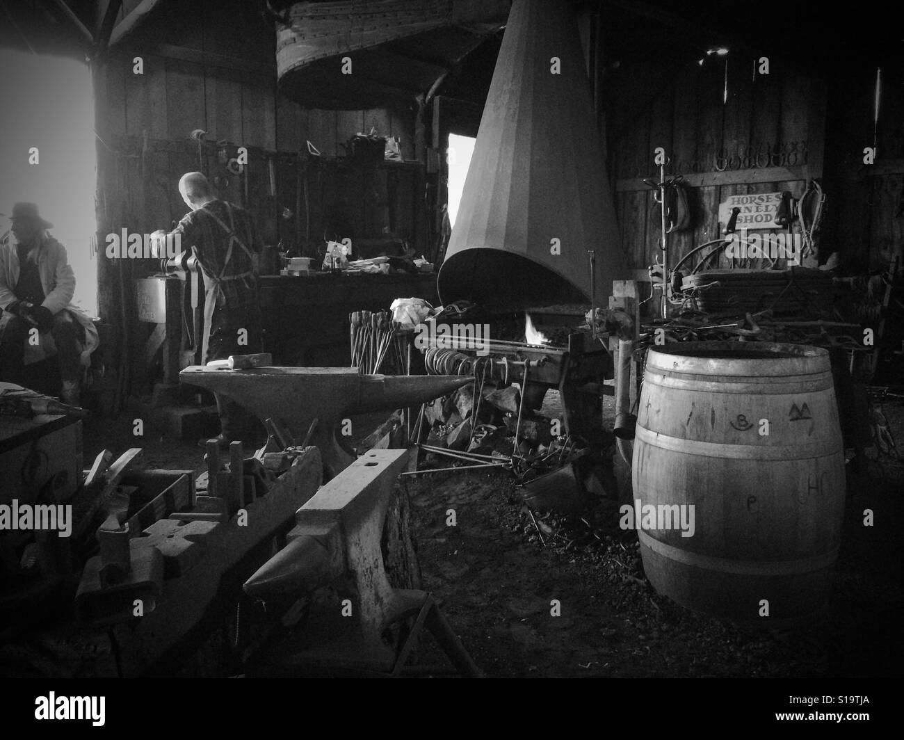 A blacksmith working in his shop on Main Street. Columbia State Historic Park, Columbia, Tuolumne County,  California, USA - Smartphone Captured Stock Image