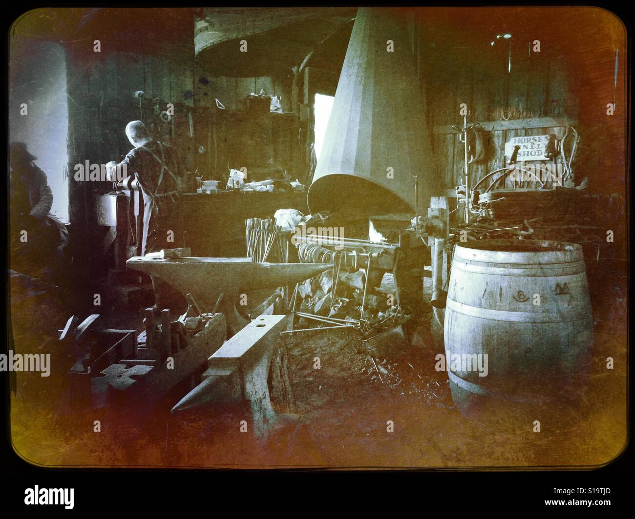 A blacksmith working in his shop on Main Street. Columbia State Historic Park, Columbia, Tuolumne County,  California, USA - Smartphone Captured Stock Image