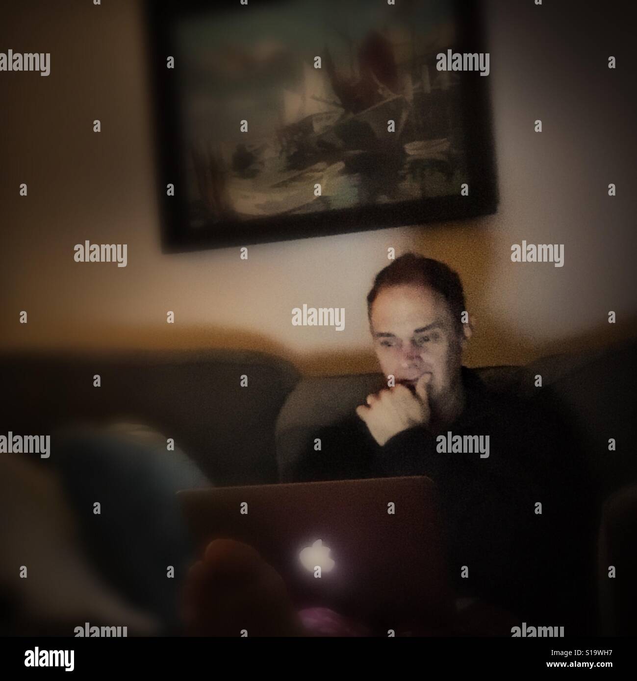 Man thinking, using laptop - Smartphone Captured Stock Image